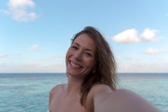 Ung kvinna i bröllopsresa som tar en selfie Hav som bakgrund royaltyfri fotografi Ung kvinna i bröllopsresa som tar en selfie Hav som bakgrund royaltyfri fotografi