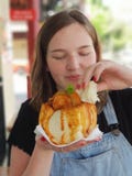 Ung kvinna som doppar bröd in i Bunny Chow curry arkivbild Ung kvinna som doppar bröd in i Bunny Chow curry arkivbild