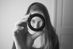 Ung kvinna som ser till och med kameralinsen och leende Fotografihjälpmedel och utrustning Beijing, China royaltyfria bilder Ung kvinna som ser till och med kameralinsen och leende Fotografihjälpmedel och utrustning Beijing, China royaltyfria bilder