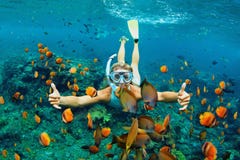 Ung kvinna som snorklar med fiskar för korallrev fotografering för bildbyråer Ung kvinna som snorklar med fiskar för korallrev fotografering för bildbyråer