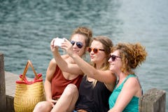 Ung kvinna tre på stranden med deras telefon arkivfoto Ung kvinna tre på stranden med deras telefon arkivfoto