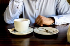 Ung man efter en angen?m tebjudning som vilar och talar p? telefonen i ett kaf? aff?rslunch, aff?rsm?ten arkivfoton Ung man efter en angen?m tebjudning som vilar och talar p? telefonen i ett kaf? aff?rslunch, aff?rsm?ten arkivfoton