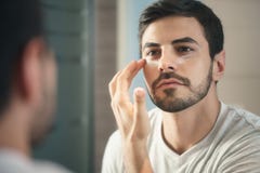 Ung man som fot applicerar anti--åldras hudomsorg för lotion Royaltyfri Fotografi Ung man som fot applicerar anti--åldras hudomsorg för lotion Royaltyfri Fotografi
