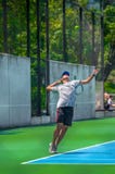 Ung man som spelar tennis på en solig dag arkivfoton Ung man som spelar tennis på en solig dag arkivfoton