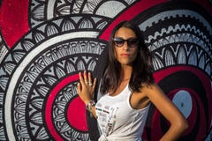 Ung medelhavs- flicka i den vita tshirten som poserar nära väggen royaltyfri foto Ung medelhavs- flicka i den vita tshirten som poserar nära väggen royaltyfri foto