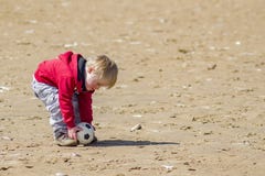 Ung pojke på stranden som förlägger bollen för en frispark arkivbilder Ung pojke på stranden som förlägger bollen för en frispark arkivbilder