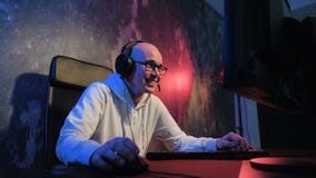 Ung pro-gamer som spelar i online-videospelet, samtal med lagspelare till och med mikrofonen Neon färgat rum e-sport lager videofilmer Ung pro-gamer som spelar i online-videospelet, samtal med lagspelare till och med mikrofonen Neon färgat rum e-sport lager videofilmer