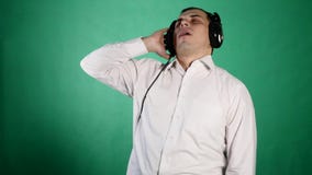 Ung rolig man med hörlurar på chroma stock video Ung rolig man med hörlurar på chroma stock video