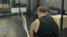 Ung vuxen man som gör crossfitgenomkörare med ledde rep stock video Ung vuxen man som gör crossfitgenomkörare med ledde rep stock video