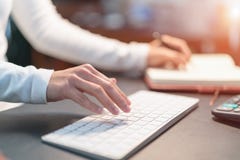 Unga affärskvinnor som skriver på tangentbordet på kontoret - applicerat filter Arkivbilder Unga affärskvinnor som skriver på tangentbordet på kontoret - applicerat filter Arkivbilder