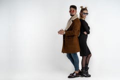 Unga bra seende par i stilfull moderiktig tillf?llig kl?der som tillbaka st?r till tillbaka att se kameran som ?ver isoleras royaltyfria bilder Unga bra seende par i stilfull moderiktig tillf?llig kl?der som tillbaka st?r till tillbaka att se kameran som ?ver isoleras royaltyfria bilder