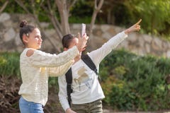 Unga flickor tar ett foto med den utomhus- smartphonen arkivfoto Unga flickor tar ett foto med den utomhus- smartphonen arkivfoto