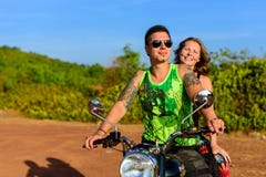 Unga h?rliga parhipsters i stilfulla kl?der p? motorcykeln som poserar mot en bl? himmel och ett gr?nt gr?s Aff?rsf?retag och arkivbilder Unga h?rliga parhipsters i stilfulla kl?der p? motorcykeln som poserar mot en bl? himmel och ett gr?nt gr?s Aff?rsf?retag och arkivbilder