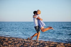 Unga lyckliga par på stranden på sommarsemestern royaltyfri fotografi Unga lyckliga par på stranden på sommarsemestern royaltyfri fotografi