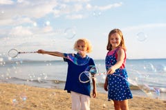 Ungar bl?ser bubblan p? stranden bubbles barnet royaltyfria bilder Ungar bl?ser bubblan p? stranden bubbles barnet royaltyfria bilder