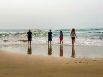 Ungar på hållande ögonen på vågor för strand royaltyfria bilder Ungar på hållande ögonen på vågor för strand royaltyfria bilder