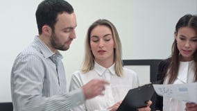 Ungt affärsfolk som diskuterar marknadsforskning med kollegor arkivfilmer Ungt affärsfolk som diskuterar marknadsforskning med kollegor arkivfilmer