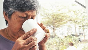 Unhappy lonely Asian senior woman with a cup of coffee alone at home, slow motion stock video footage Unhappy lonely Asian senior woman with a cup of coffee alone at home, slow motion stock video footage