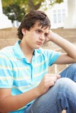 Unhappy Male Teenage Student Sitting Outside Stock Photography Unhappy Male Teenage Student Sitting Outside Stock Photography