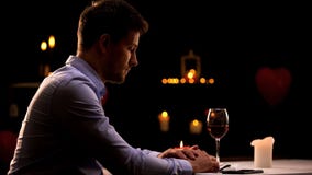 Unhappy man sitting alone in restaurant, waiting for woman, unsuccessful date stock photos Unhappy man sitting alone in restaurant, waiting for woman, unsuccessful date stock photos