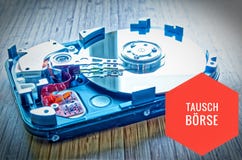 Unité de disque dur 3 5 pouces comme stockage de données avec la carte mère sur une table en bambou et en allemand Tauschbörse d photo libre de droits Unité de disque dur 3 5 pouces comme stockage de données avec la carte mère sur une table en bambou et en allemand Tauschbörse d photo libre de droits
