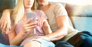 unrecognisable αγκαλιά ζευγών στον καναπέ που ελέγχει το smartphone στο σύγχρονο σπίτι τους Γυναίκα που κρατά το κινητό τηλέφωνο, Στοκ εικόνες με δικαίωμα ελεύθερης χρήσης unrecognisable αγκαλιά ζευγών στον καναπέ που ελέγχει το smartphone στο σύγχρονο σπίτι τους Γυναίκα που κρατά το κινητό τηλέφωνο, Στοκ εικόνες με δικαίωμα ελεύθερης χρήσης