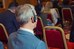 business people using headphones for translation during event . bald security guard with the headset to control peo stock photography business people using headphones for translation during event . bald security guard with the headset to control peo stock photography