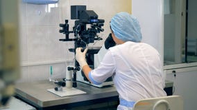 Unrecognizable żeński naukowiec pracuje z mikroskopem przy nowożytnym laboratorium zbiory wideo Unrecognizable żeński naukowiec pracuje z mikroskopem przy nowożytnym laboratorium zbiory wideo