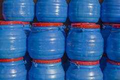 Uns grandes tambores plásticos azuis com tampões e os punhos vermelhos fotografia de stock Uns grandes tambores plásticos azuis com tampões e os punhos vermelhos fotografia de stock