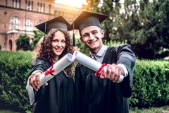 Unsere Eltern sind auf uns so stolz Die glücklichen Absolvent stehen in der Universität, die in den Umhängen mit Diplomen in der lizenzfreies stockbild Unsere Eltern sind auf uns so stolz Die glücklichen Absolvent stehen in der Universität, die in den Umhängen mit Diplomen in der lizenzfreies stockbild