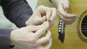 Unterrichtende Frau des Mannes, zum der Gitarre zu spielen stock footage Unterrichtende Frau des Mannes, zum der Gitarre zu spielen stock footage