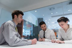 Unterzeichnende Lastenhefte der jungen Paare auf Partnern zurück lizenzfreie stockbilder Unterzeichnende Lastenhefte der jungen Paare auf Partnern zurück lizenzfreie stockbilder