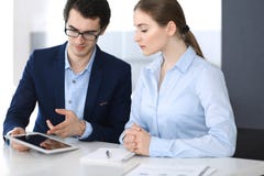 Uomini d'affari e donna che utilizza il computer della compressa nell'ufficio moderno Colleghi o responsabili di societ? nel luog immagini stock Uomini d'affari e donna che utilizza il computer della compressa nell'ufficio moderno Colleghi o responsabili di societ? nel luog immagini stock