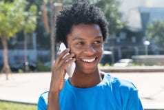 Uomo afroamericano giovane di risata al telefono cellulare immagine stock libera da diritti Uomo afroamericano giovane di risata al telefono cellulare immagine stock libera da diritti