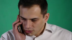 Uomo arrabbiato di affari che parla sul telefono cellulare isolato sopra fondo verde archivi video Uomo arrabbiato di affari che parla sul telefono cellulare isolato sopra fondo verde archivi video