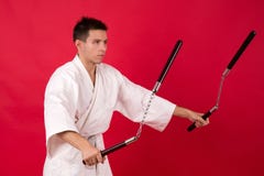 Uomo in arti marziali di pratica del kimono Kata matrice di nunchaku dell'esposizione fotografia stock Uomo in arti marziali di pratica del kimono Kata matrice di nunchaku dell'esposizione fotografia stock