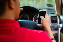 Uomo asiatico che texting mentre guidando