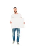 Uomo barbuto bello che tiene insegna in bianco, immagine stock Uomo barbuto bello che tiene insegna in bianco, immagine stock