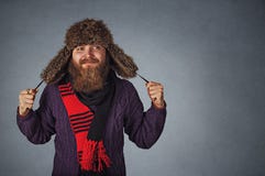 Uomo in cappello di pelliccia, scraf rosso e maglione porpora scuro guardanti per parteggiare fantasticando fotografie stock Uomo in cappello di pelliccia, scraf rosso e maglione porpora scuro guardanti per parteggiare fantasticando fotografie stock