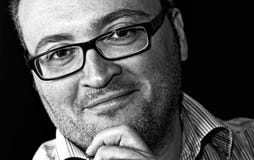 Uomo caucasico barbuto occhialuto sorridente del colpo monocromatico immagini stock libere da diritti Uomo caucasico barbuto occhialuto sorridente del colpo monocromatico immagini stock libere da diritti