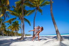 Uomo che dà sulle spalle giro all'amica alla spiaggia caraibica fotografie stock Uomo che dà sulle spalle giro all'amica alla spiaggia caraibica fotografie stock