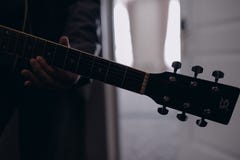 Uomo che gioca il primo piano della chitarra all'interno sulla foto fotografia stock libera da diritti Uomo che gioca il primo piano della chitarra all'interno sulla foto fotografia stock libera da diritti
