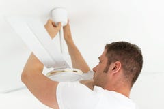 Uomo che installa fan fotografia stock Uomo che installa fan fotografia stock