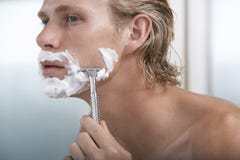 Uomo che si rade nel bagno fotografia stock libera da diritti Uomo che si rade nel bagno fotografia stock libera da diritti