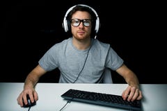 Uomo in cuffia avricolare che gioca il video gioco del computer Immagini Stock Uomo in cuffia avricolare che gioca il video gioco del computer Immagini Stock