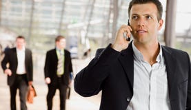 Uomo d'affari che comunica sul telefono mobile fotografia stock Uomo d'affari che comunica sul telefono mobile fotografia stock