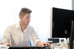 Uomo d'affari che lavora nell'ufficio fotografia stock Uomo d'affari che lavora nell'ufficio fotografia stock
