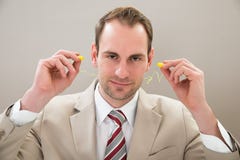 Uomo d'affari con il tappo per le orecchie fotografia stock libera da diritti Uomo d'affari con il tappo per le orecchie fotografia stock libera da diritti