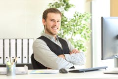 Uomo d'affari fiero che posa all'ufficio immagine stock Uomo d'affari fiero che posa all'ufficio immagine stock