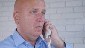 Uomo d'affari Make una telefonata facendo uso della linea terrestre dell'ufficio fotografia stock Uomo d'affari Make una telefonata facendo uso della linea terrestre dell'ufficio fotografia stock